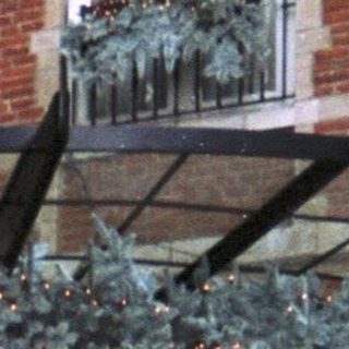 Woman stands outside a decorated hotel entrance.