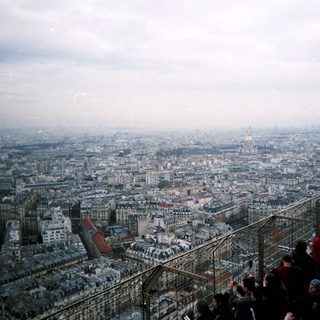 High-angle view of Paris cityscape with people observing.