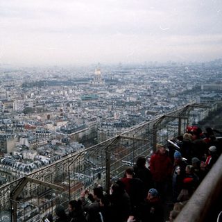 High-angle view of Paris cityscape with people observing.