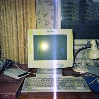 Vintage computer setup with a monitor and desk.