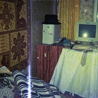 Vintage computer setup in a dimly lit, cluttered room.