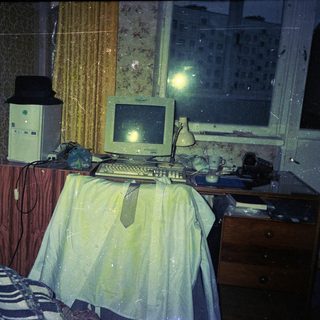 Vintage computer setup in a dimly lit, cluttered room.