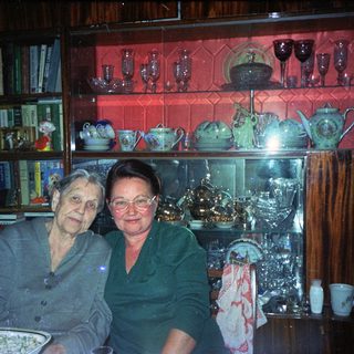 Two women seated at a table with decorative china.