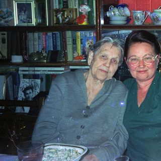 Two women seated at a table with decorative china.
