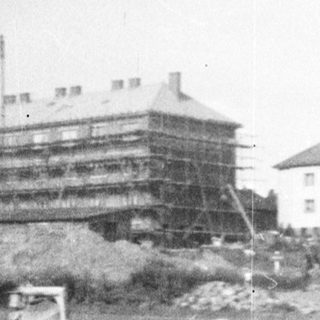 Construction site with buildings and a stone wall.