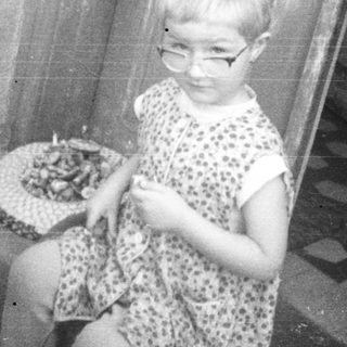 Two children playing with dolls near a doorway.