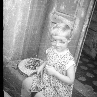 Two children playing with dolls near a doorway.