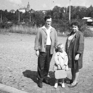 Family portrait on a gravelly road in an older setting.
