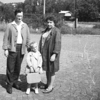 Family portrait on a gravelly road in an older setting.