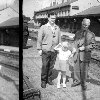 Family portrait at a vintage railway station platform.