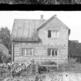 Construction of a house, workers present, rural setting.
