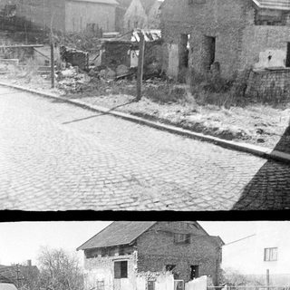 Dilapidated building alongside a cobblestone street and railway.