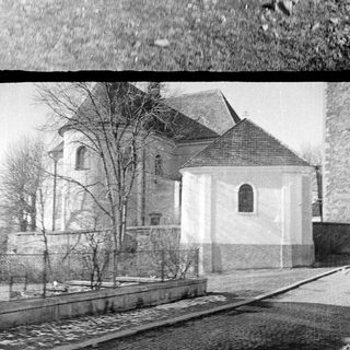 Here's a brief summary of the image: Pile of rubble with a building and church in background.