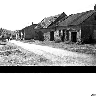 Here's a brief summary of the image: Row of old buildings along a dirt road.