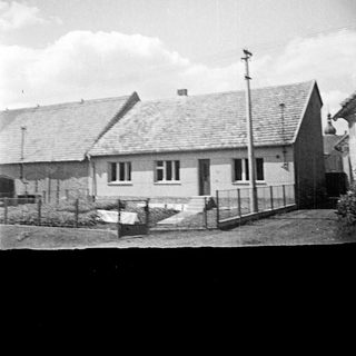 Black and white image of a house with a garden.