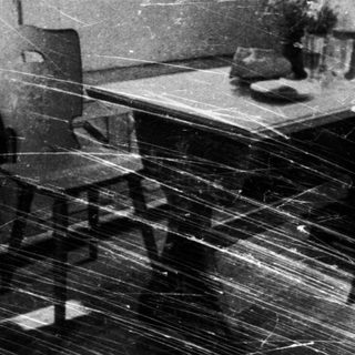 Black and white image showcases vintage furniture and room decor.
