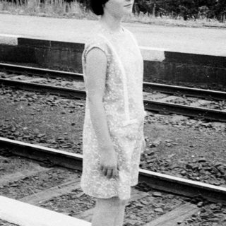 Black and white photo of people near a train platform.