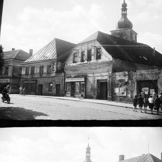 Black and white photo shows a town square with buildings.