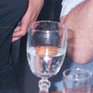 Here's a brief summary of the image: Couple seated at a table, man with his head down.