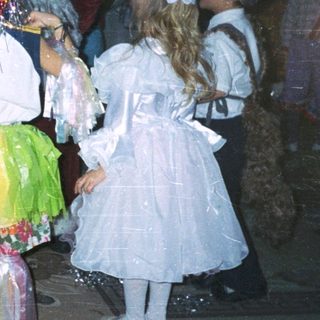 Children in costumes with Santa Claus at a festive event.