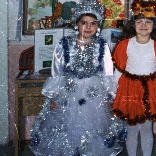 Children in costumes perform in a classroom setting.