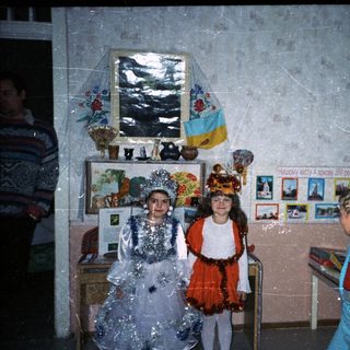 Children in costumes perform in a classroom setting.