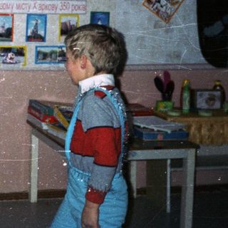 Children in costumes perform in a classroom setting.