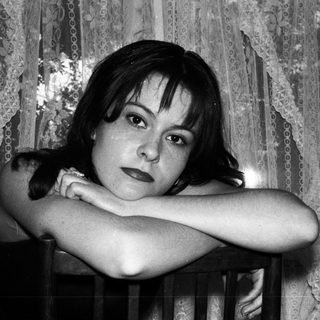 Black and white portrait of a woman with arms crossed.