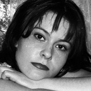 Black and white portrait of a woman with arms crossed.