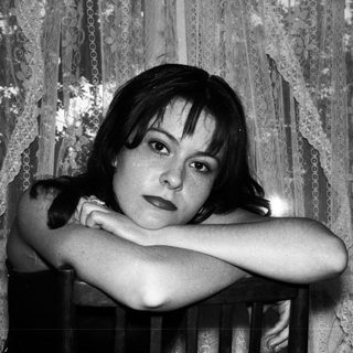Black and white portrait of a woman with arms crossed.
