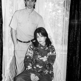 Black and white photo of a couple seated and standing.