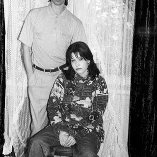 Black and white photo of a couple seated and standing.