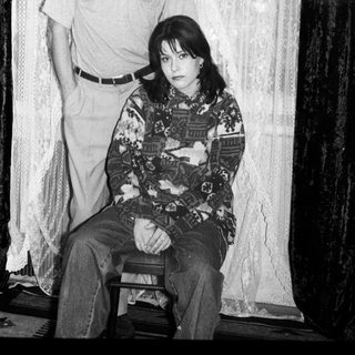 Black and white photo of a couple seated and standing.