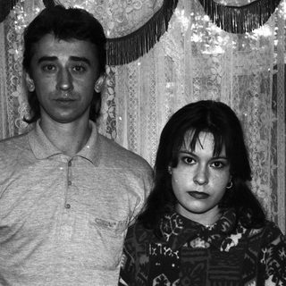 Black and white portrait of a couple standing indoors.