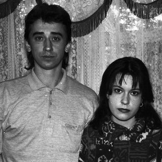 Black and white portrait of a couple standing indoors.