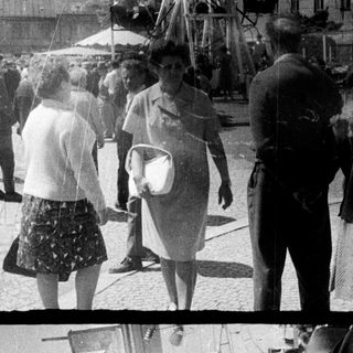 Vintage fairground with people enjoying a carousel ride.