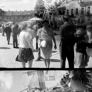 Vintage fairground with people enjoying a carousel ride.