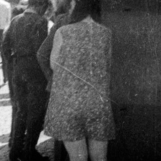 Group of people standing and conversing outdoors.