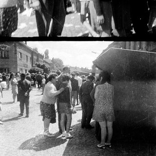 Group of people standing and conversing outdoors.