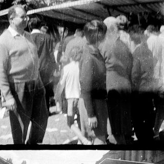 Group of people standing and conversing outdoors.