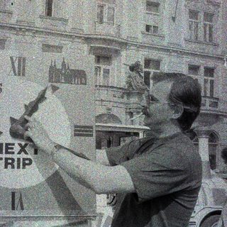 Man points to a sign advertising "Next Trip."
