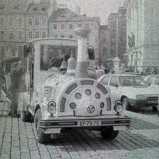Vintage truck parked on a cobblestone street with buildings.