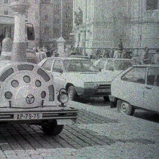 Vintage truck parked on a cobblestone street with buildings.