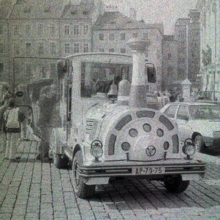 Vintage truck parked on a cobblestone street with buildings.