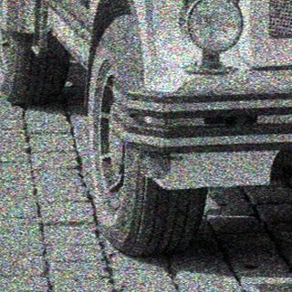 Vintage truck parked on a cobblestone street with buildings.