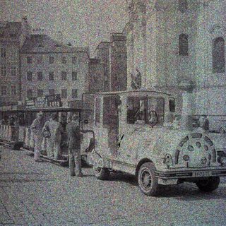 Vintage bus parked on a street with buildings.