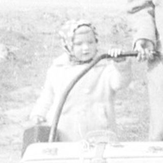 Person pulling a sled with a baby in a snowy landscape.