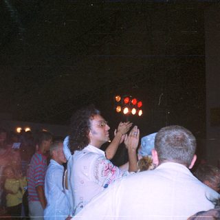 Crowd scene with people looking upwards at lights.