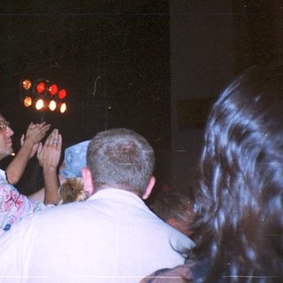 Crowd scene with people looking upwards at lights.