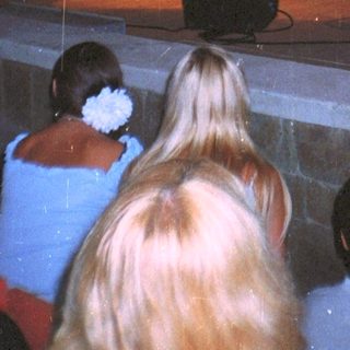 Audience viewing a stage performance at night.